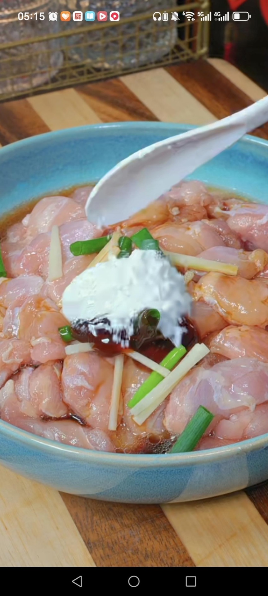 Toss the cubed chicken thigh with the minced scallion whites, ginger, Shaoxing wine, light soy sauce, oyster sauce, and cornstarch, mix until every piece is coated, then drizzle 1