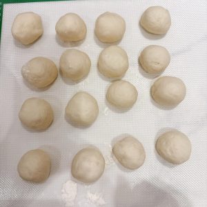 Round each portion into a ball, cover them, and let them rest for 15-20 minutes.