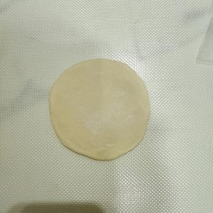 Use a rolling pin to roll each portion into a wrapper that is thicker in the middle and thinner at the edges.
