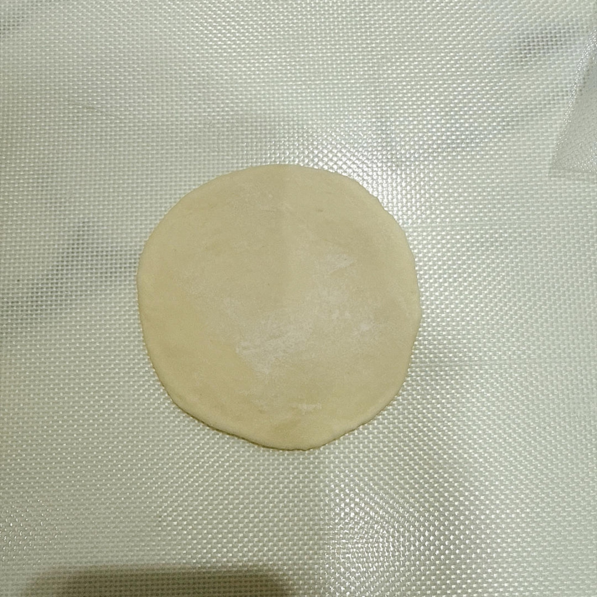 Use a rolling pin to roll each portion into a wrapper that is thicker in the middle and thinner at the edges.
