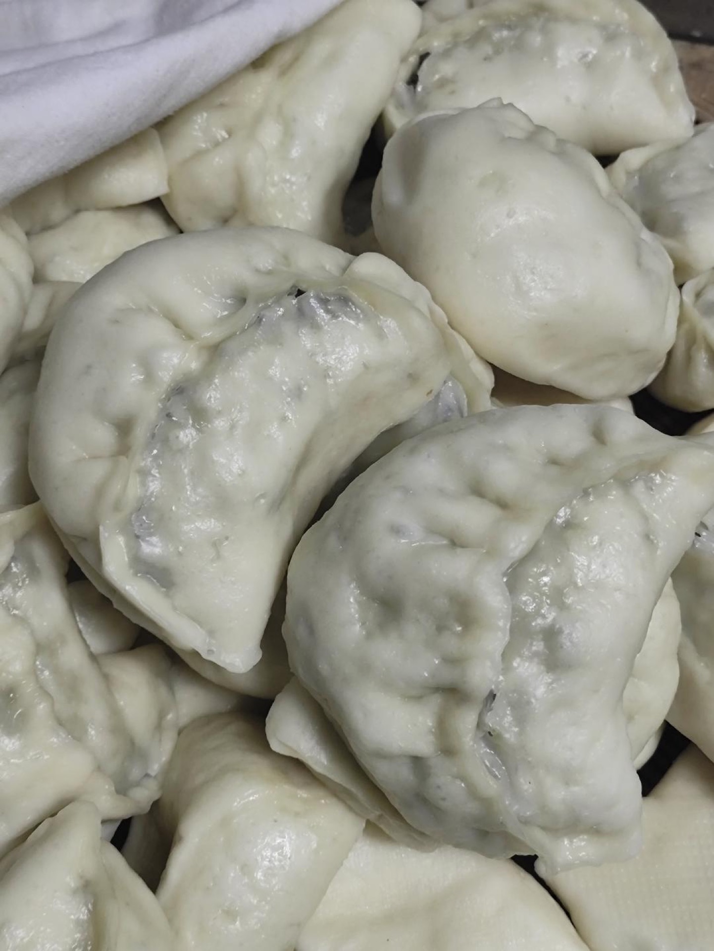 Punch down the risen dough and knead again. Divide into portions, roll each into a circle, and fill with a spoonful of filling. Pleat and seal the edges to form the buns.