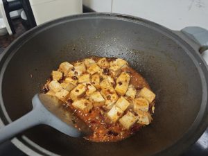 Add the tofu and stock, toss gently to coat, then add the cornstarch slurry in three or four small additions, simmering until the sauce clings to every cube, and fold the beef cris