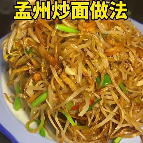 A plate of Mengzhou fried noodles with crispy golden noodles, pork, and bean sprouts in savory gravy