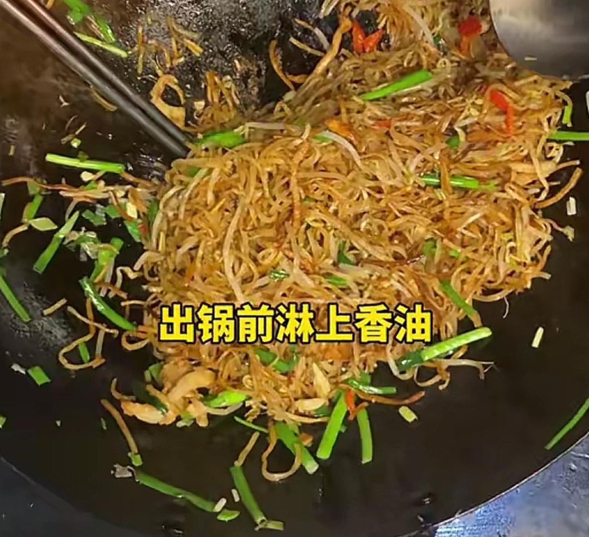 Once the gravy has mostly cooked down, add the scallion greens and minced garlic, start tossing and mixing, and drizzle in a little sesame oil; after everything is evenly combined,