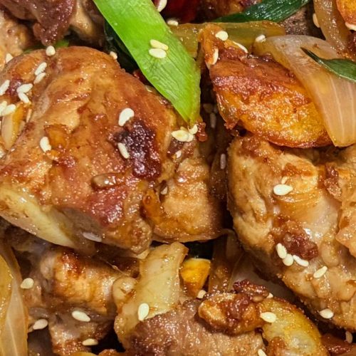 One-pot dry pot pork ribs with crisp potatoes, onion, and dried chilies in a wok
