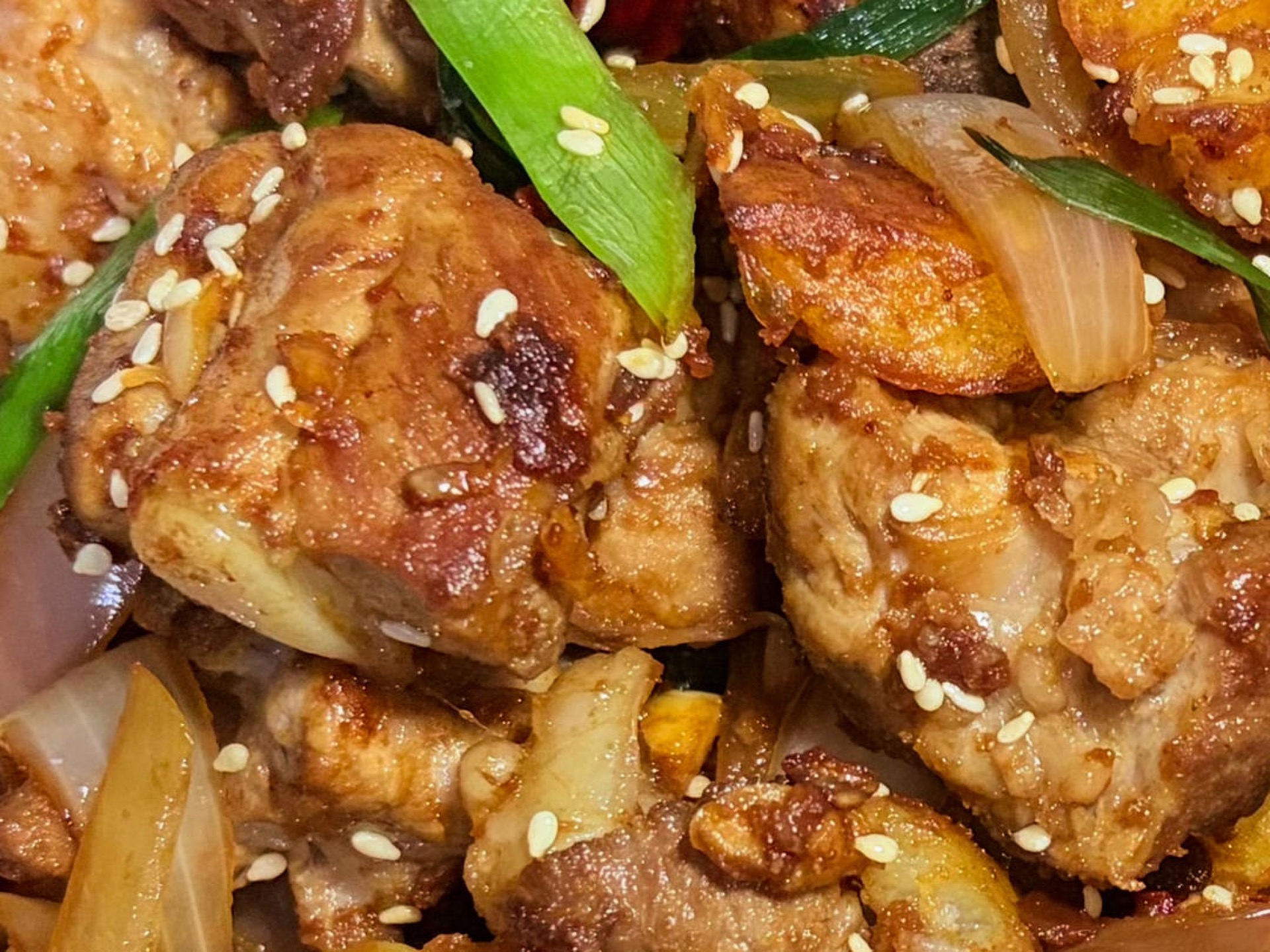 One-pot dry pot pork ribs with crisp potatoes, onion, and dried chilies in a wok