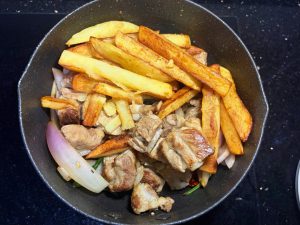 Add the ribs and potatoes, stir-fry over high heat until the onion is just cooked.