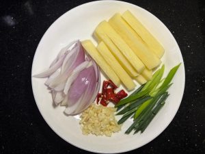 Peel and cut the potatoes into thick batons, cut the garlic sprouts into segments, slice the onion, cut the dried chilies into segments, and mince the garlic.