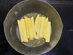 Heat oil in a wok, add the potatoes, and pan-fry them — you can cover the wok with a lid during frying so they cook through more easily.