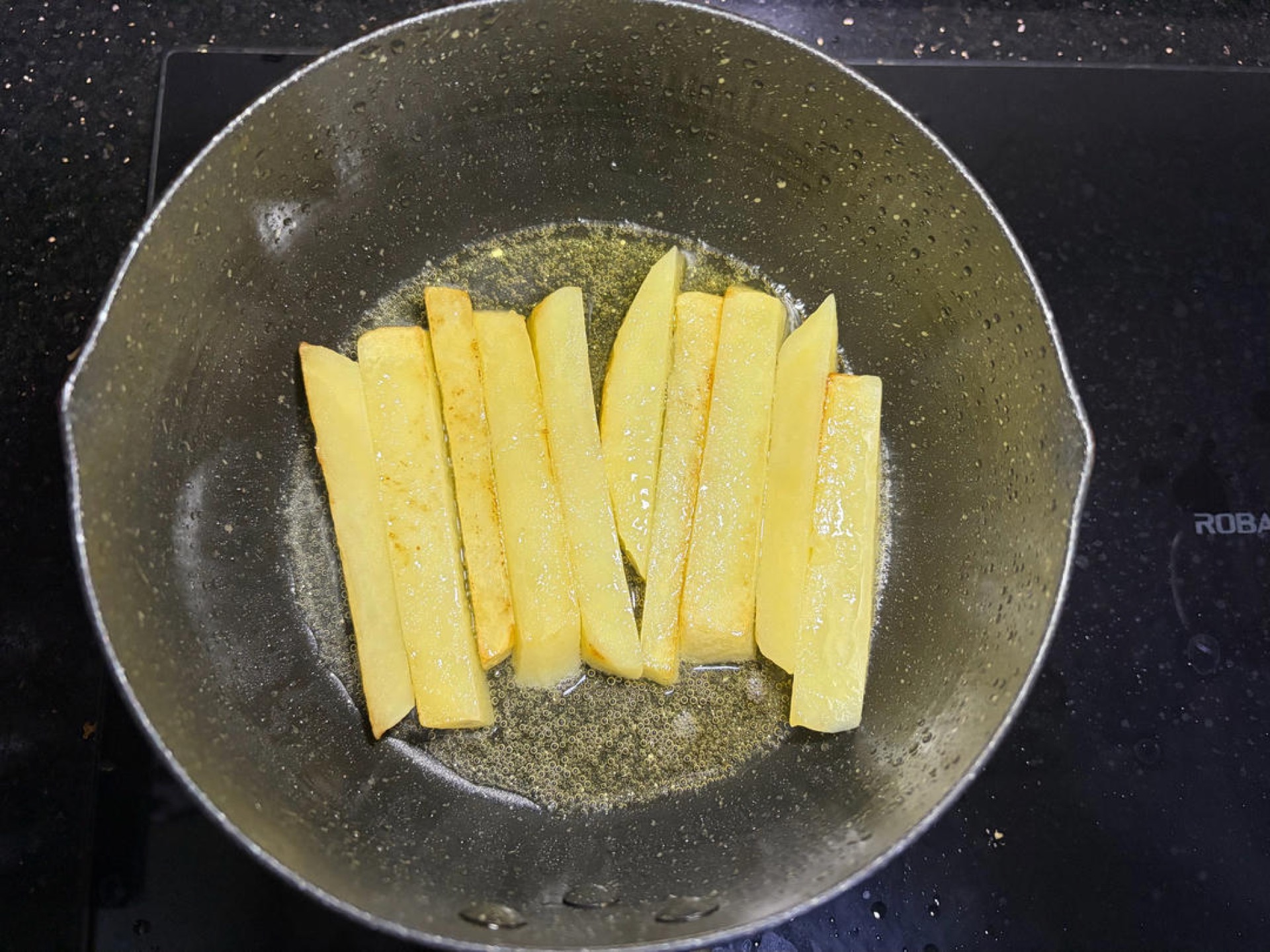 Heat oil in a wok, add the potatoes, and pan-fry them — you can cover the wok with a lid during frying so they cook through more easily.