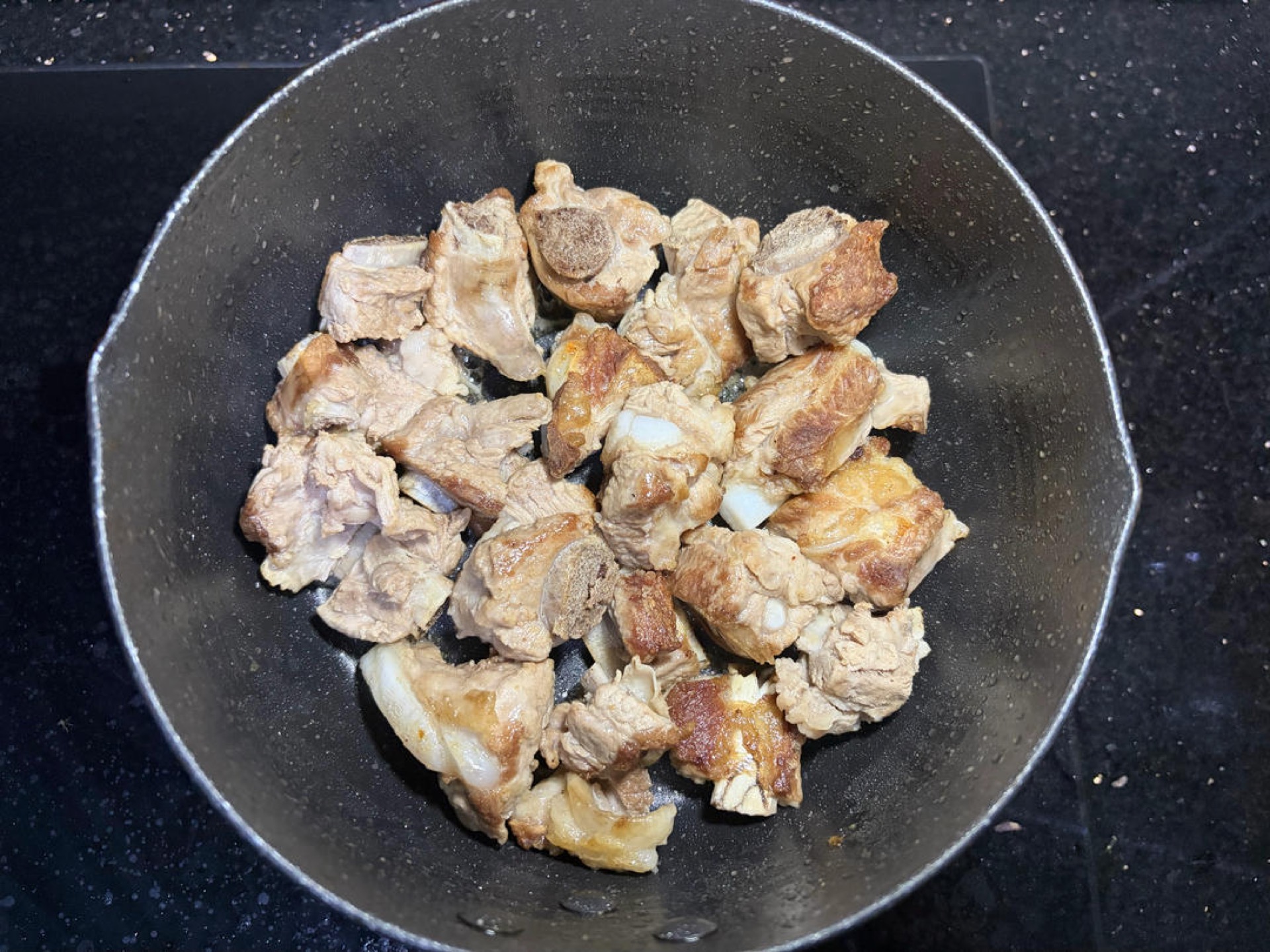 Heat a little oil in a wok, add the braised ribs, and stir-fry over medium-low heat until the surface is faintly golden, then scoop them out.