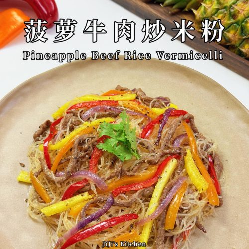 Pineapple beef fried rice noodles on a white plate with strips of pineapple, beef, and red and orange bell pepper