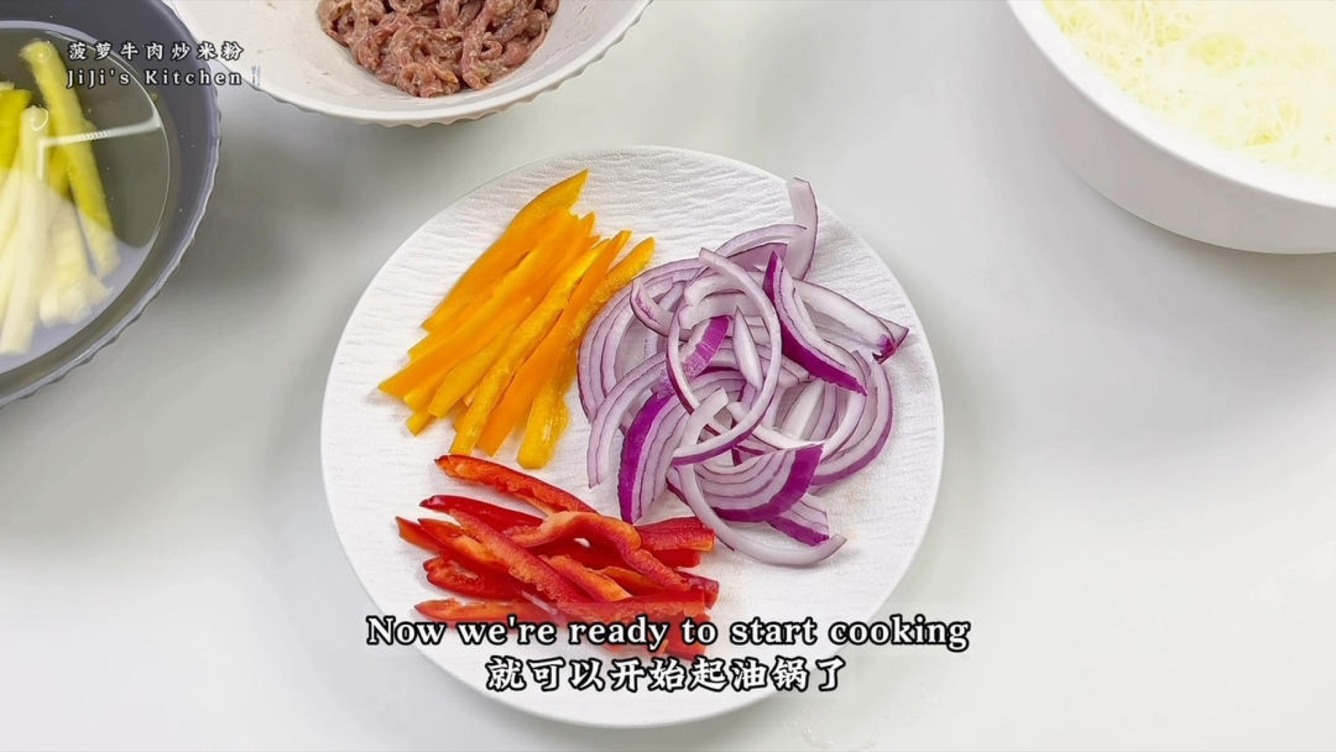 Cut the red and orange sweet peppers into thin strips, and slice the onion into thin strips as well.