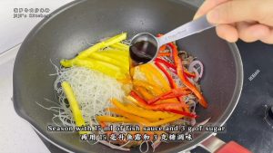 Add the rice noodles, the pepper strips, and the pineapple, season with fish sauce and sugar, and keep tossing everything quickly.