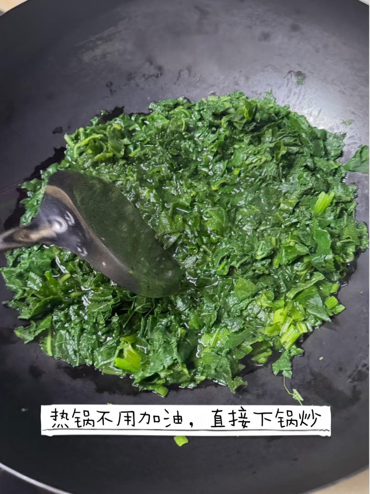 Heat a wok over medium-high heat, add the chopped pumpkin leaves straight into the dry wok, and stir them around briefly for about a minute until they collapse and turn a deeper gr