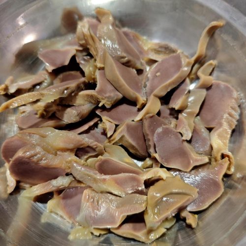 Sliced salted duck gizzards arranged on a plate