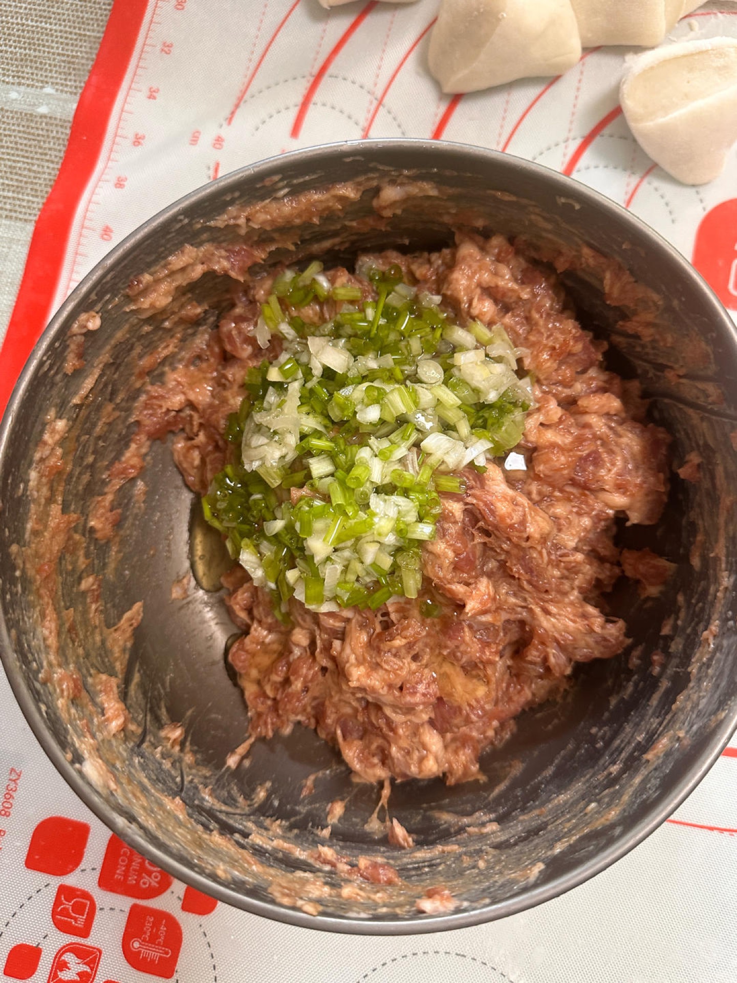Once the dough has risen, take the filling out of the refrigerator and pour the scallion oil into it.