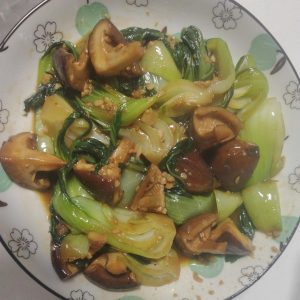 Shiitake bok choy in soy sauce served on a white plate