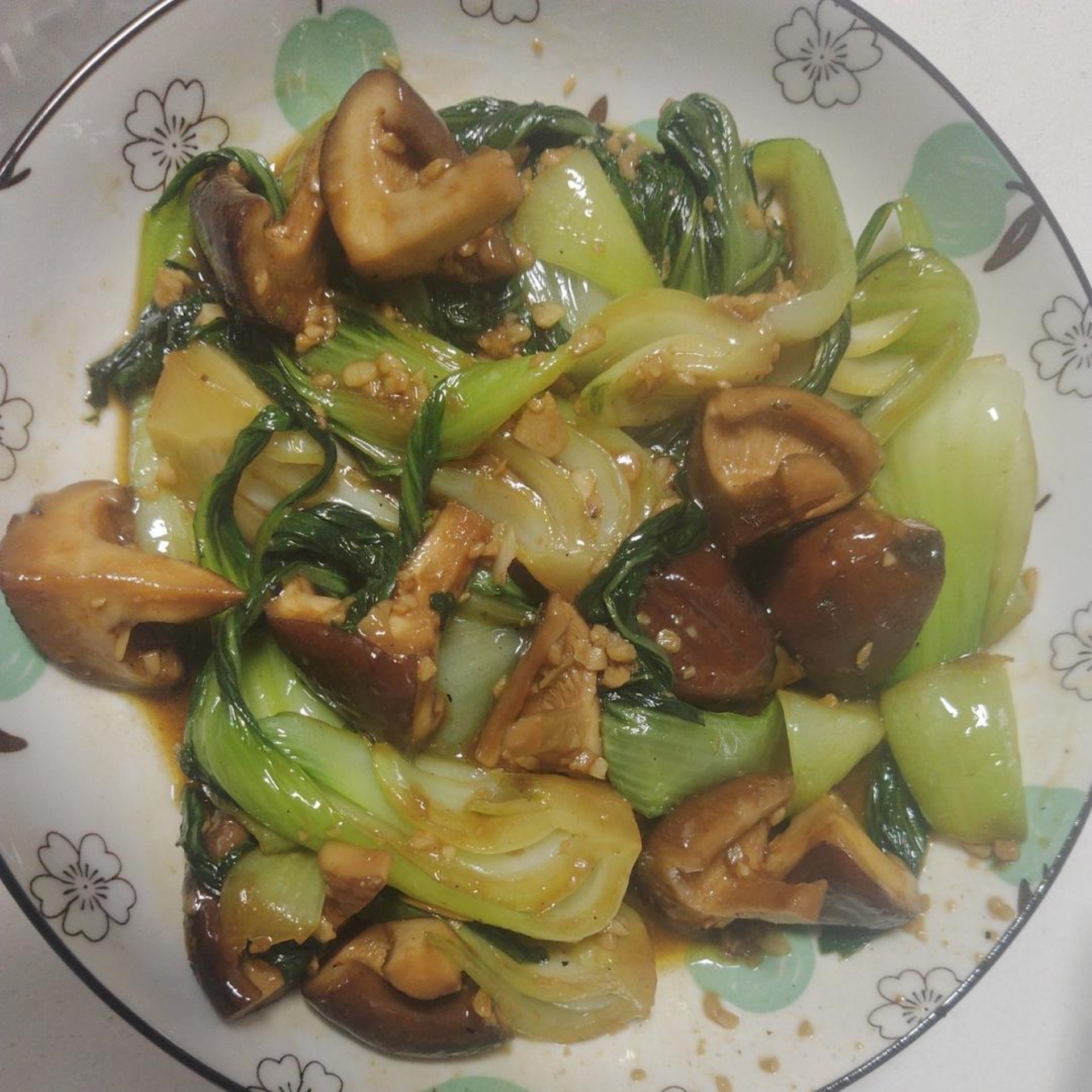 Shiitake bok choy in soy sauce served on a white plate