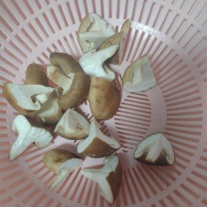 Wash four shiitake mushrooms, cut each into quarters, and get them ready for blanching.