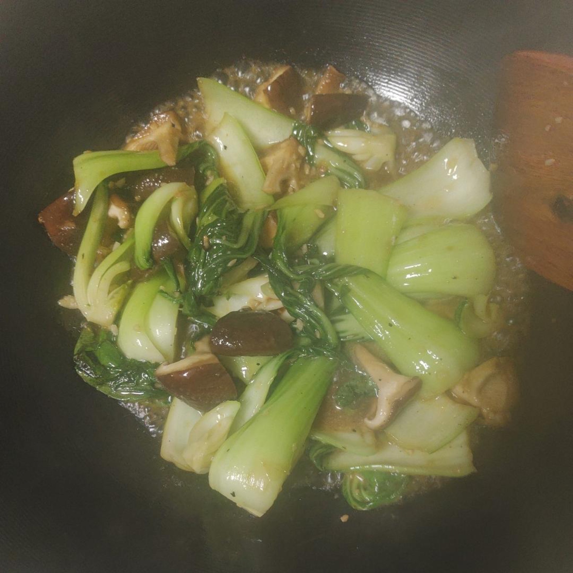 Turn the heat to high, heat the wok with cool oil, add the minced garlic and stir until fragrant, then immediately add the bok choy and mushrooms, tossing constantly so they don't