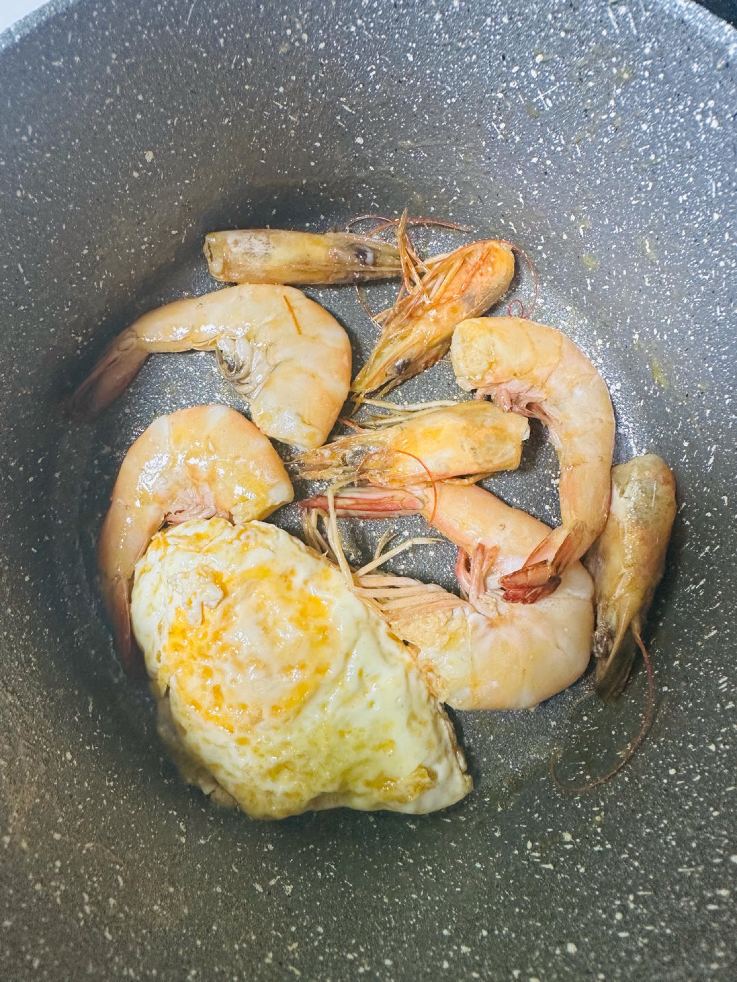 Heat a wok over high heat with a generous amount of oil, fry a fried egg on one side while pressing the shrimp heads on the other to render out the shrimp roe, add the julienned gi