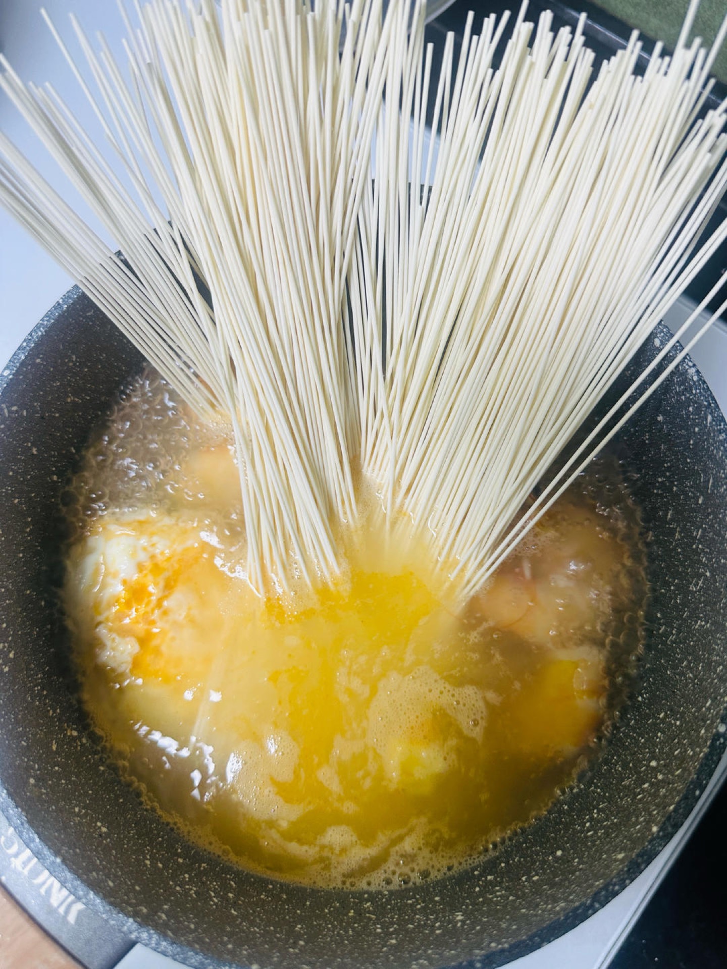 Once the water boils, add the thin noodles, loosen them with chopsticks, and cook until they are half-soft and sink into the broth.