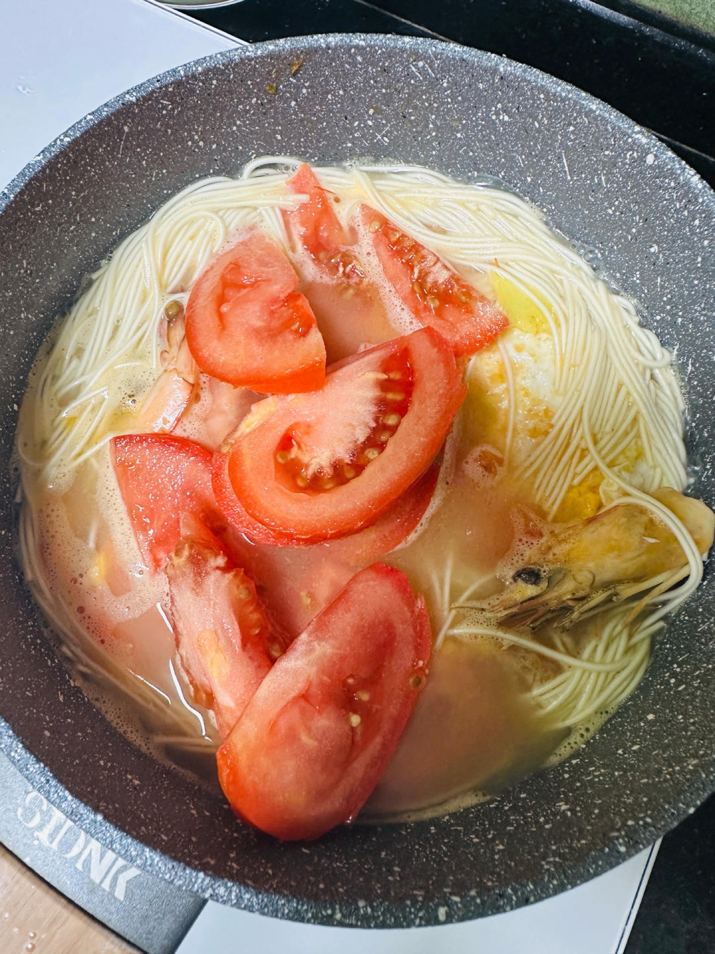 Add the tomato wedges, season with salt, and simmer until the tomato softens.