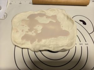 Flatten the dough out, pour in the fresh yeast, and slowly knead it in until evenly combined.