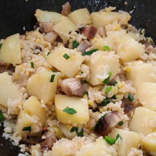 Soy sauce pork potato rice served in a wok with scallions on top