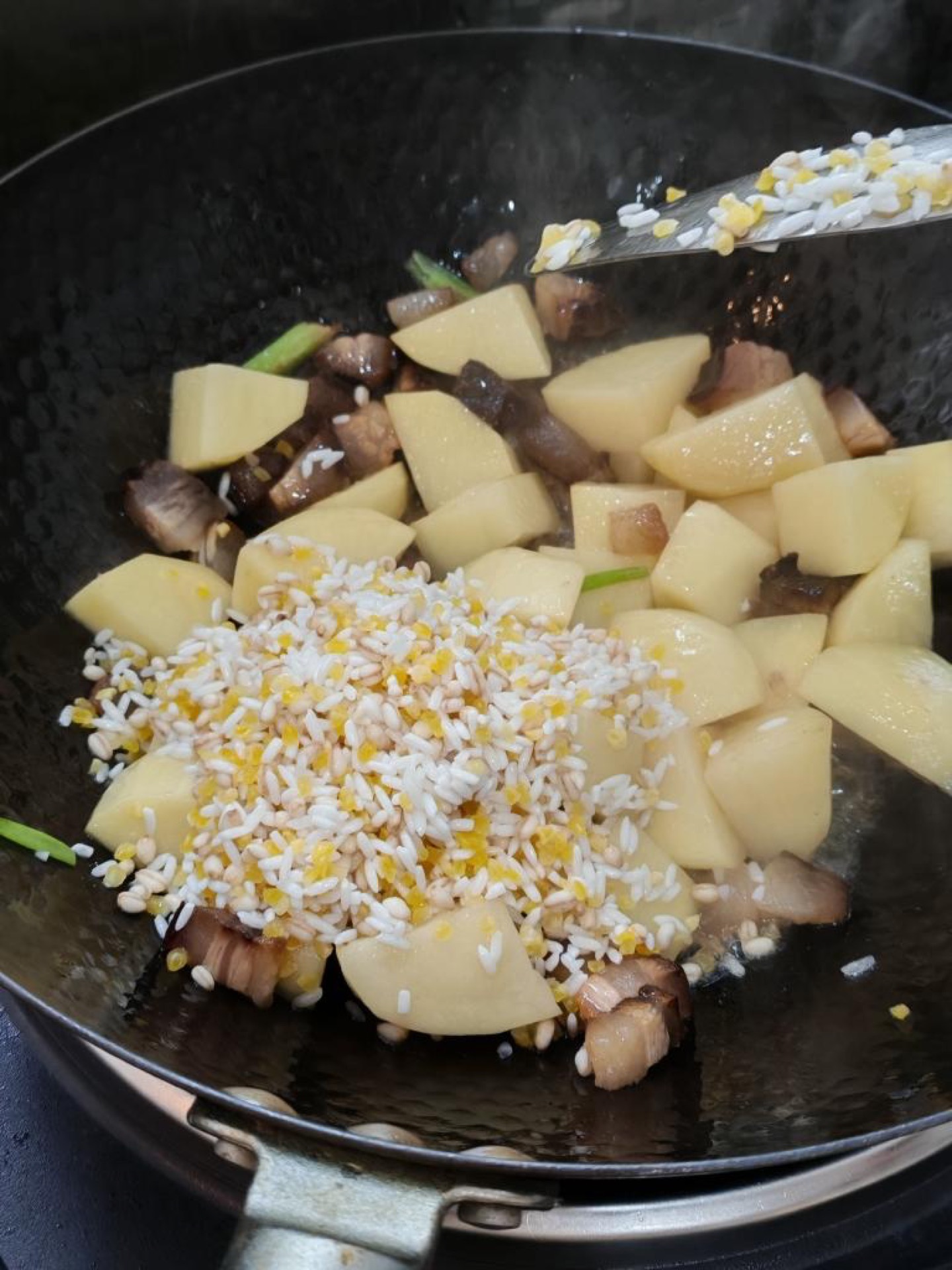 Heat the oil in a wok and stir-fry the pork and potato chunks together over medium heat until the pork releases its aroma and the potatoes are lightly coated.