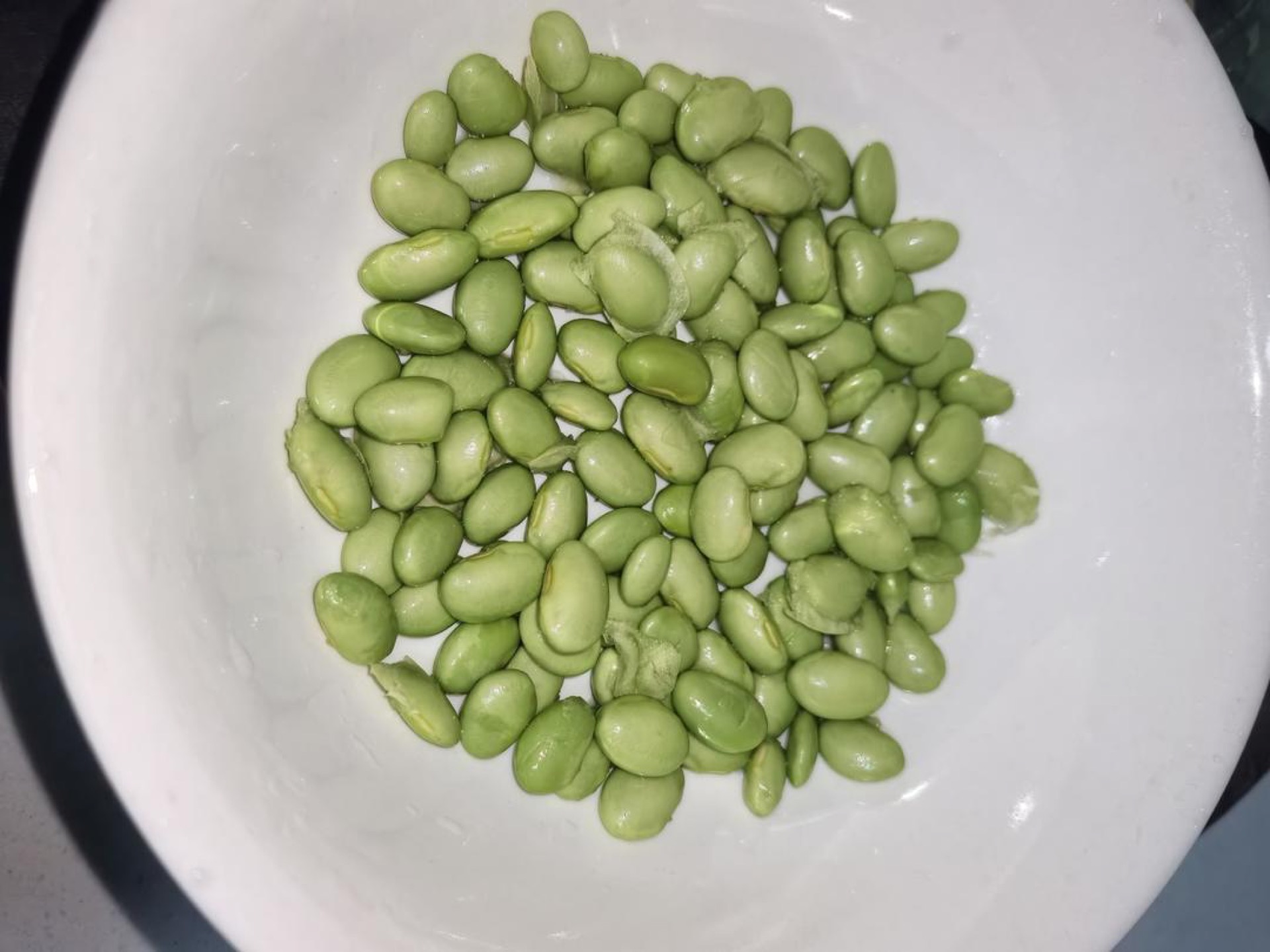 Rinse the edamame clean and spread it in an even layer across the bottom of a deep heatproof bowl.