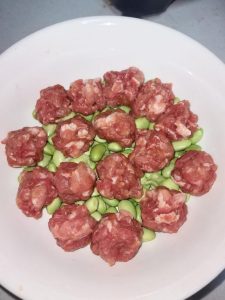 Roll the marinated pork into evenly sized meatballs, about 1 inch across, and lay them in a single layer on top of the edamame.