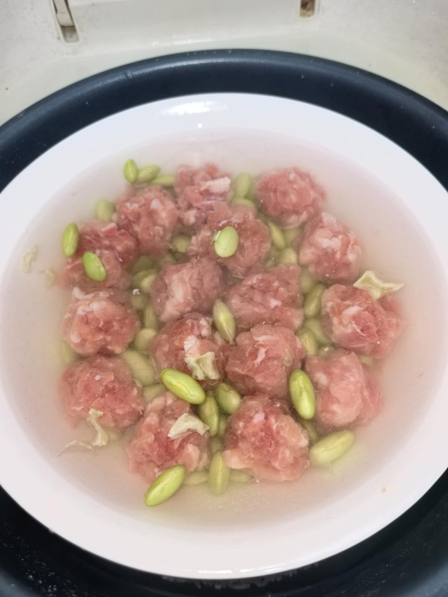 Pour the water gently down the side of the bowl, set it in the steamer, and steam until the meatballs are cooked through, about 15 to 20 minutes.
