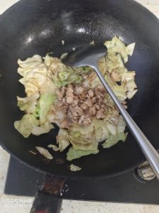 Add the seasonings — oyster sauce, sugar, salt, and cumin to taste — then return the pork to the wok and toss everything together.