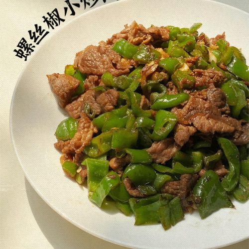 Screw pepper pork stir-fry served on a plate with blistered green peppers and thin pork slices