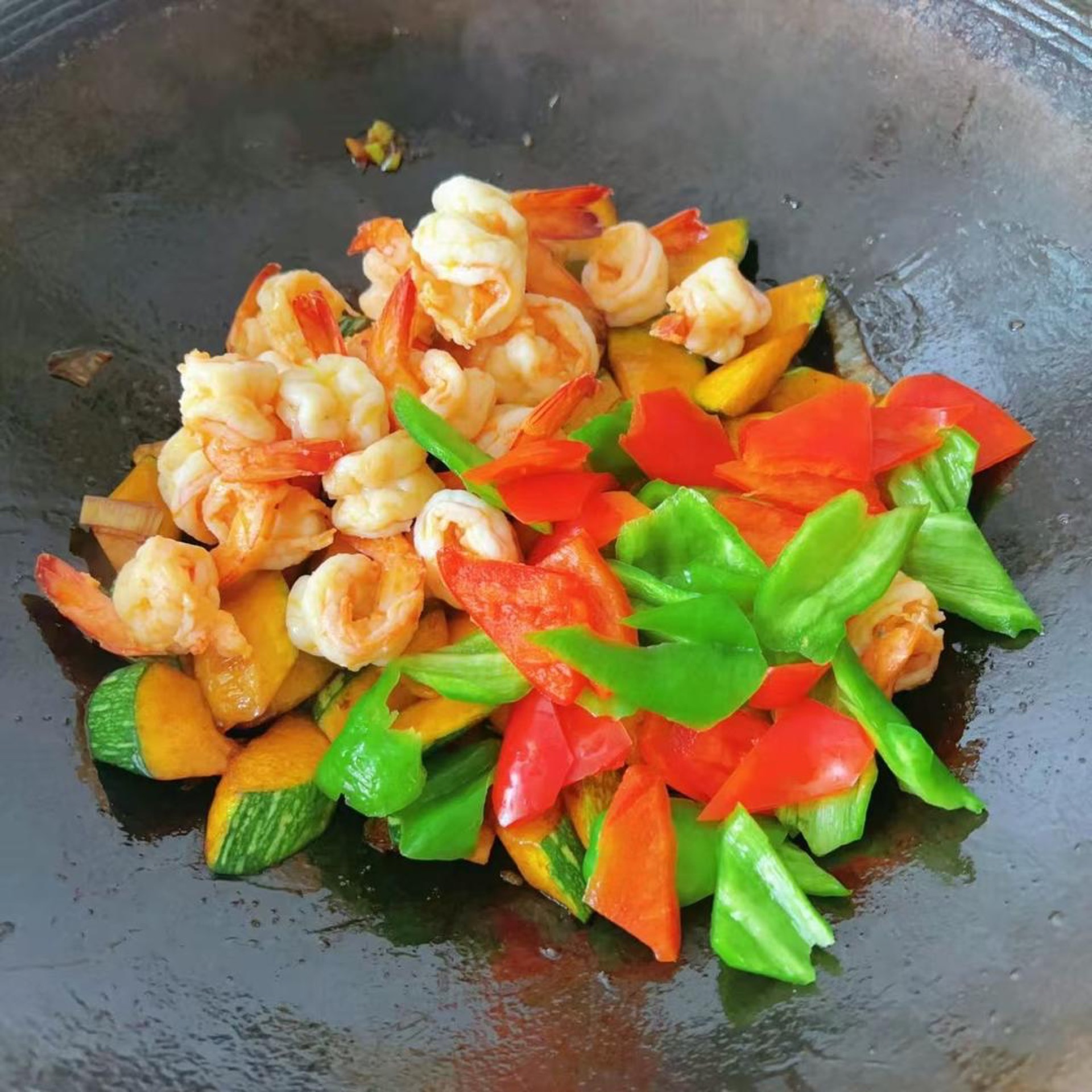 Stir-fry the pumpkin until just tender, then return the seared shrimp and the peppers, season with salt, and toss everything evenly.