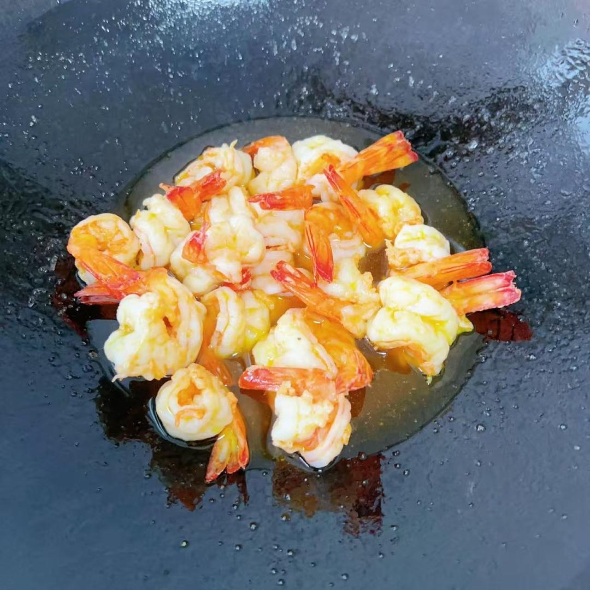 Heat oil in the wok, slide in the shrimp tails, and stir-fry just until they lose their raw look, then drain and set aside.