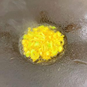 In a clean wok with a little oil, fry the scallion, ginger, and garlic until fragrant.