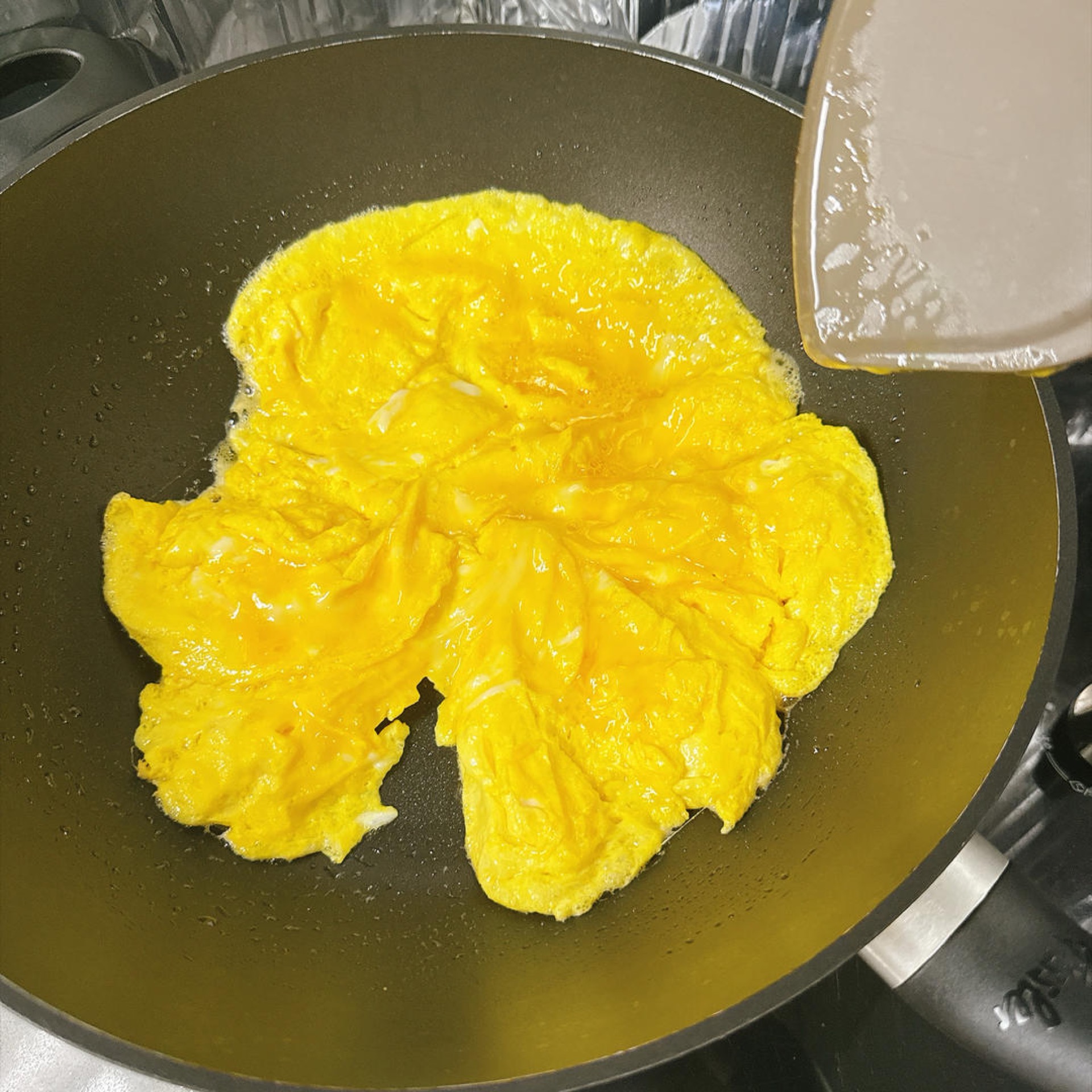 The egg liquid firms up into soft curds.