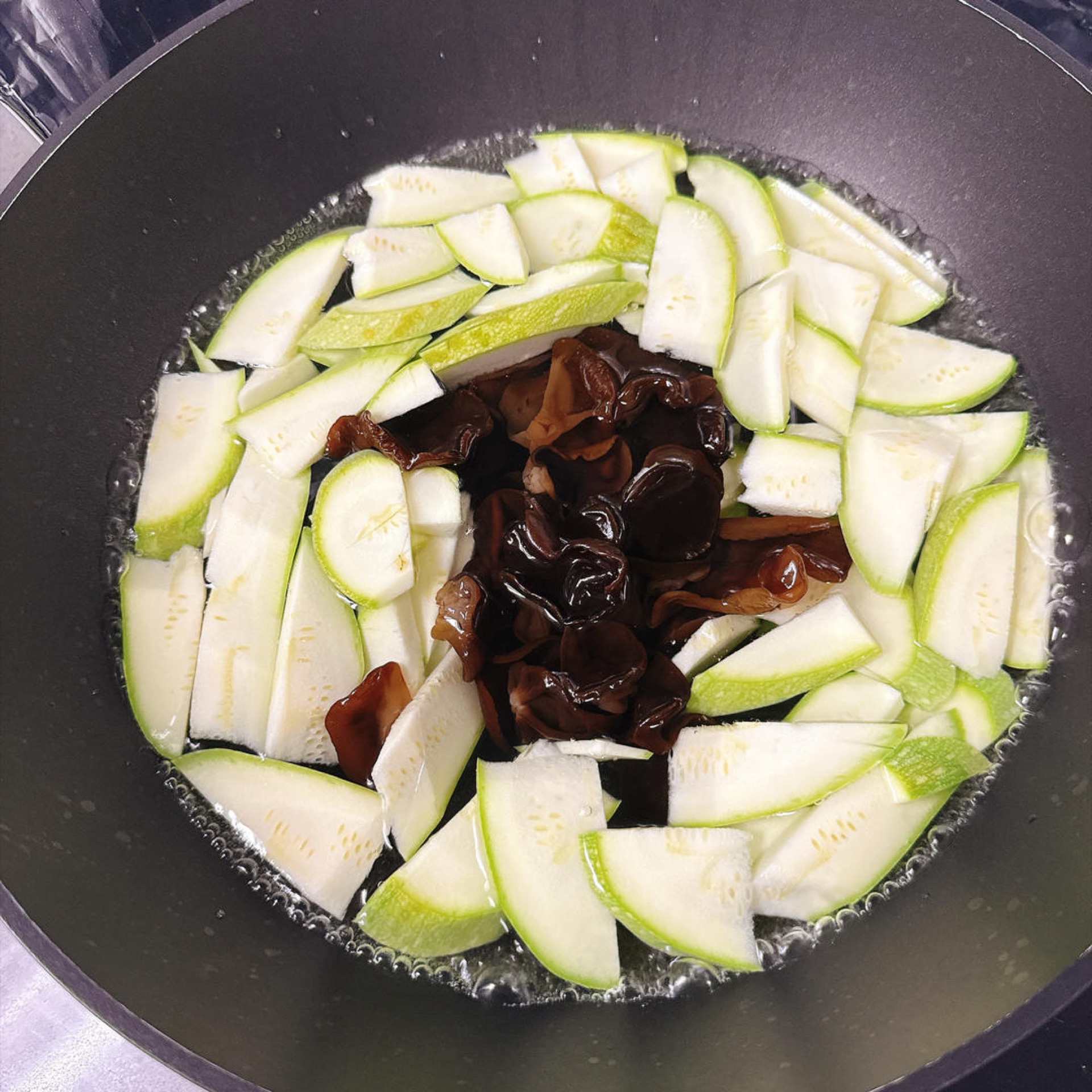 Add the zucchini and wood ear mushrooms to the boiling water for a quick blanch.