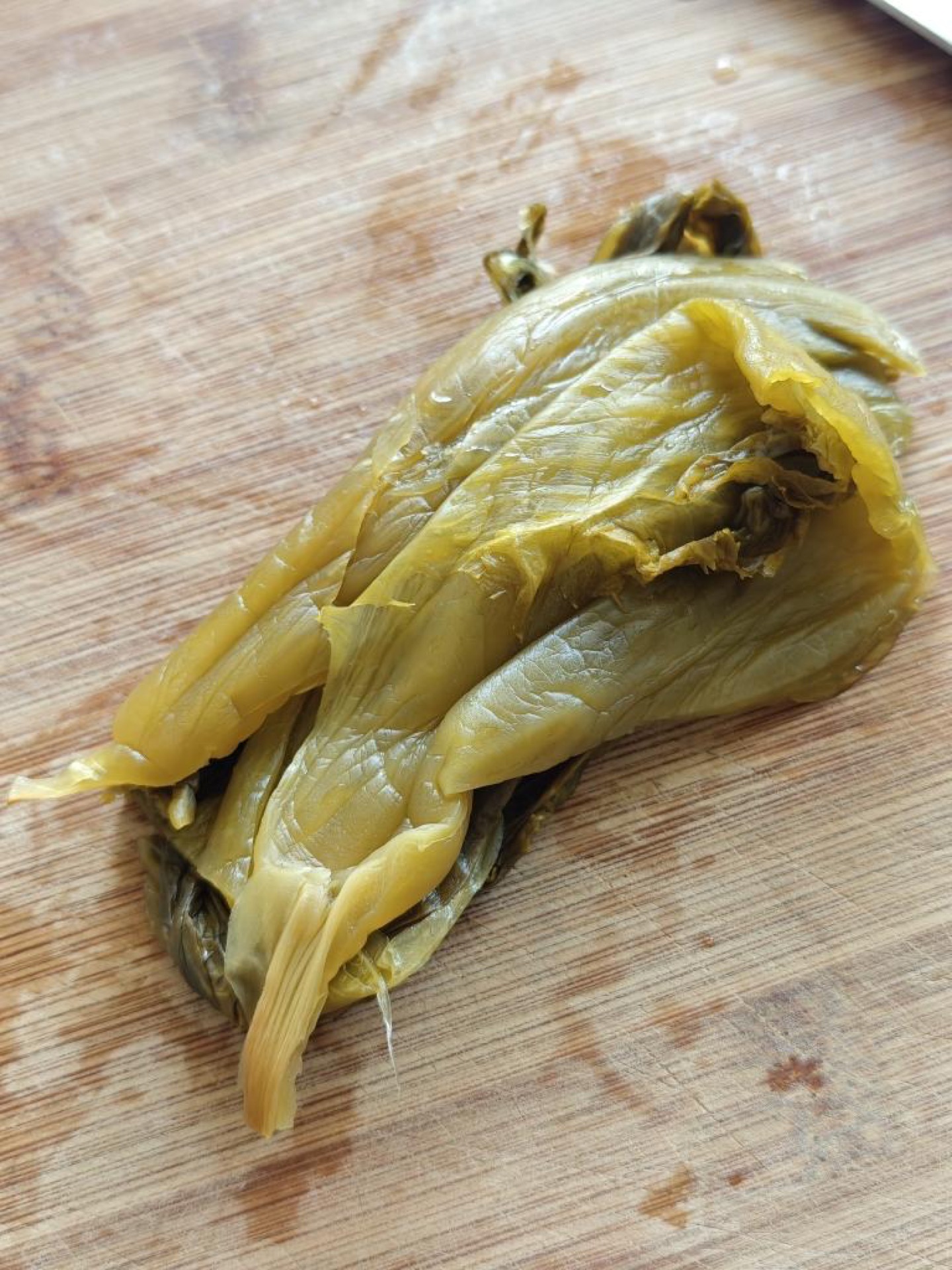 Take two stalks of pickled mustard greens and cut them into fine shreds.