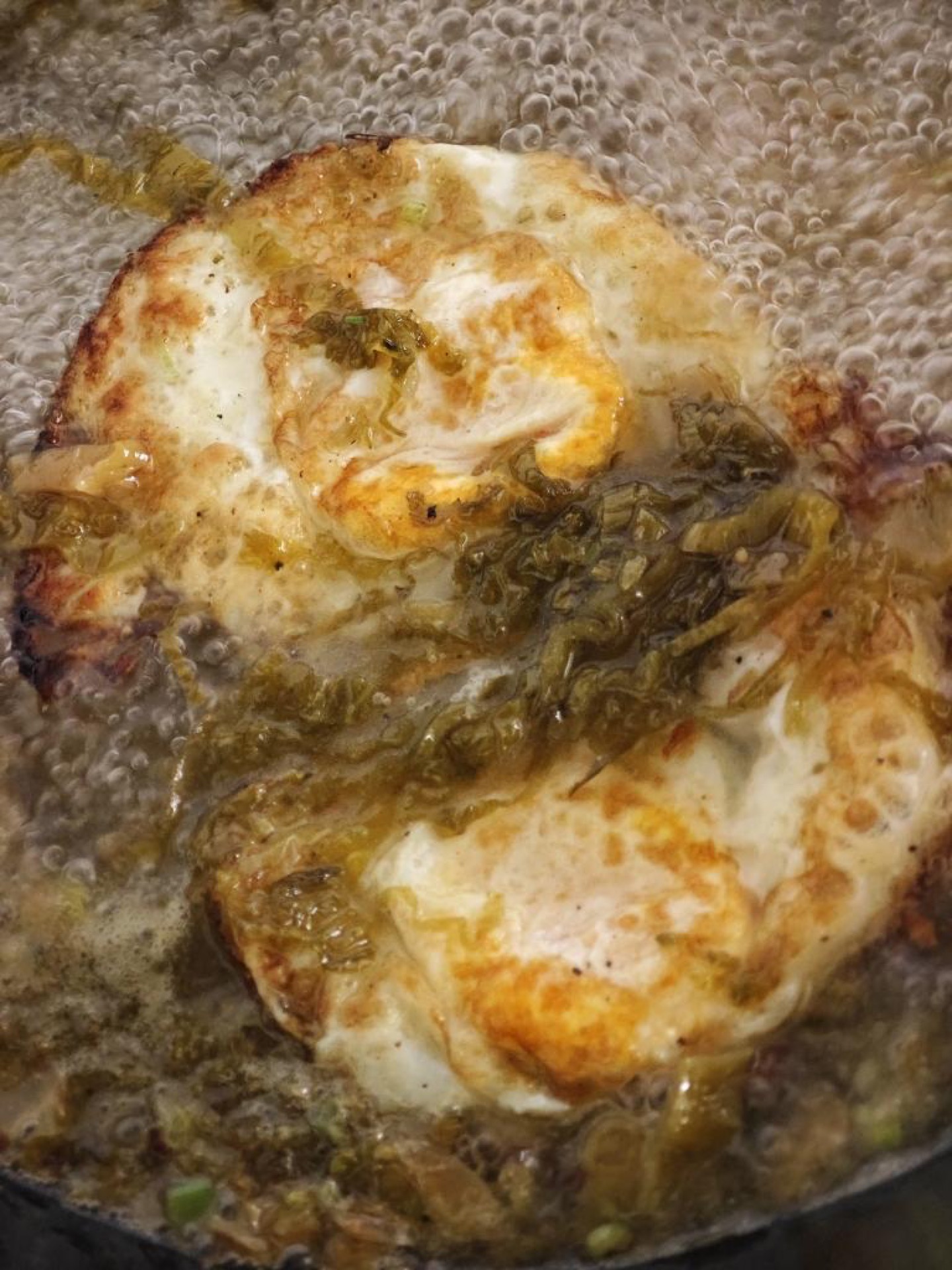 Next, drop the fried eggs into the broth and let them bubble for a while, so they soak up the sour, savory soup like sponges.
