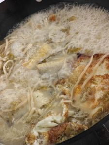 Save the best fillets for plating, then slide the rest of the fried fish back into the wok and let the pieces soak briefly in the rich broth.