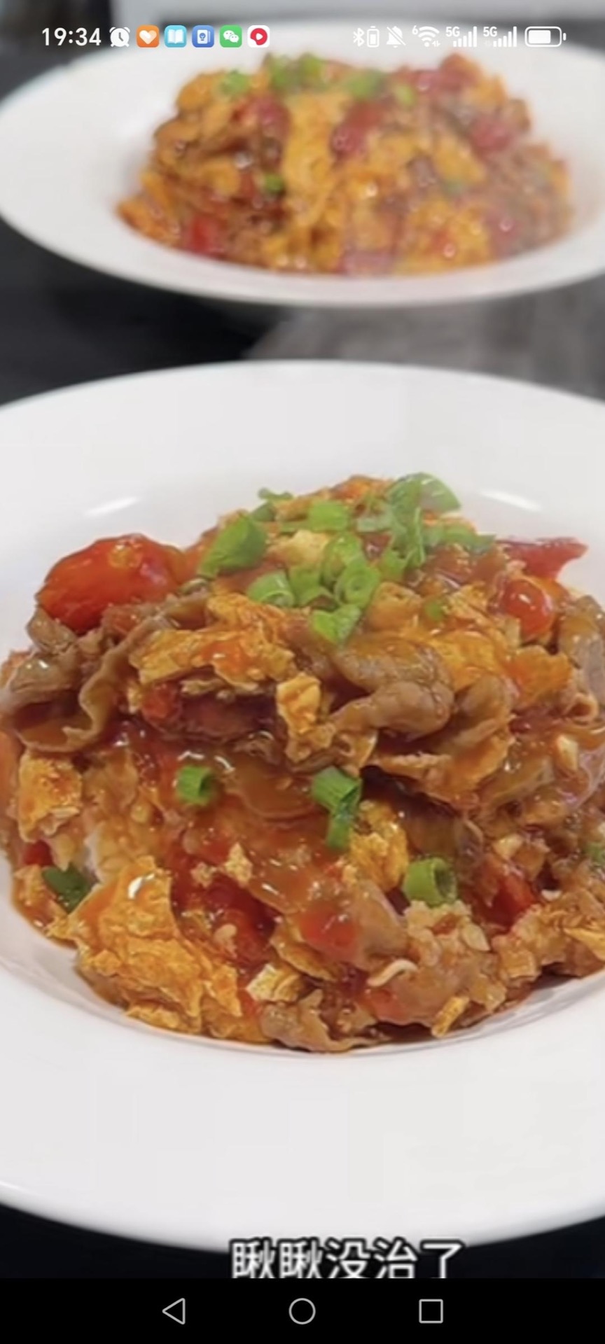 Tomato beef and egg rice bowl in a white bowl with glossy tomato sauce, tender beef slices, fried eggs and scallions over steamed rice