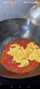 Add the tomato wedges, press them down with your spatula until they break apart into a jammy pulp, stir in the light soy sauce, then return the fried eggs to the wok.