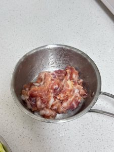 Mix the pork with 1 g salt and 5 g light soy sauce, then add half an egg white and stir until fully absorbed. Finally, add 10 g potato starch and mix until evenly coated.