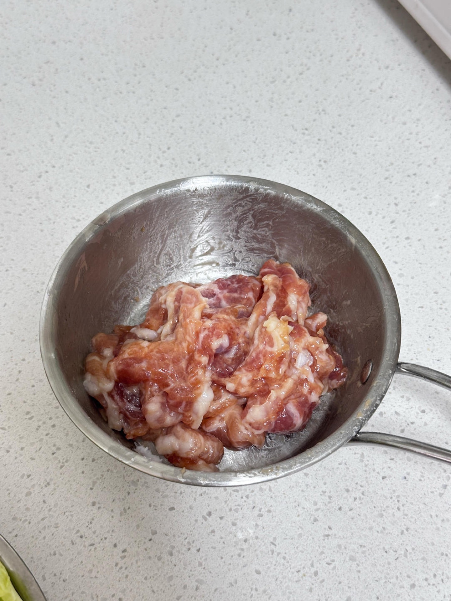 Mix the pork with 1 g salt and 5 g light soy sauce, then add half an egg white and stir until fully absorbed. Finally, add 10 g potato starch and mix until evenly coated.