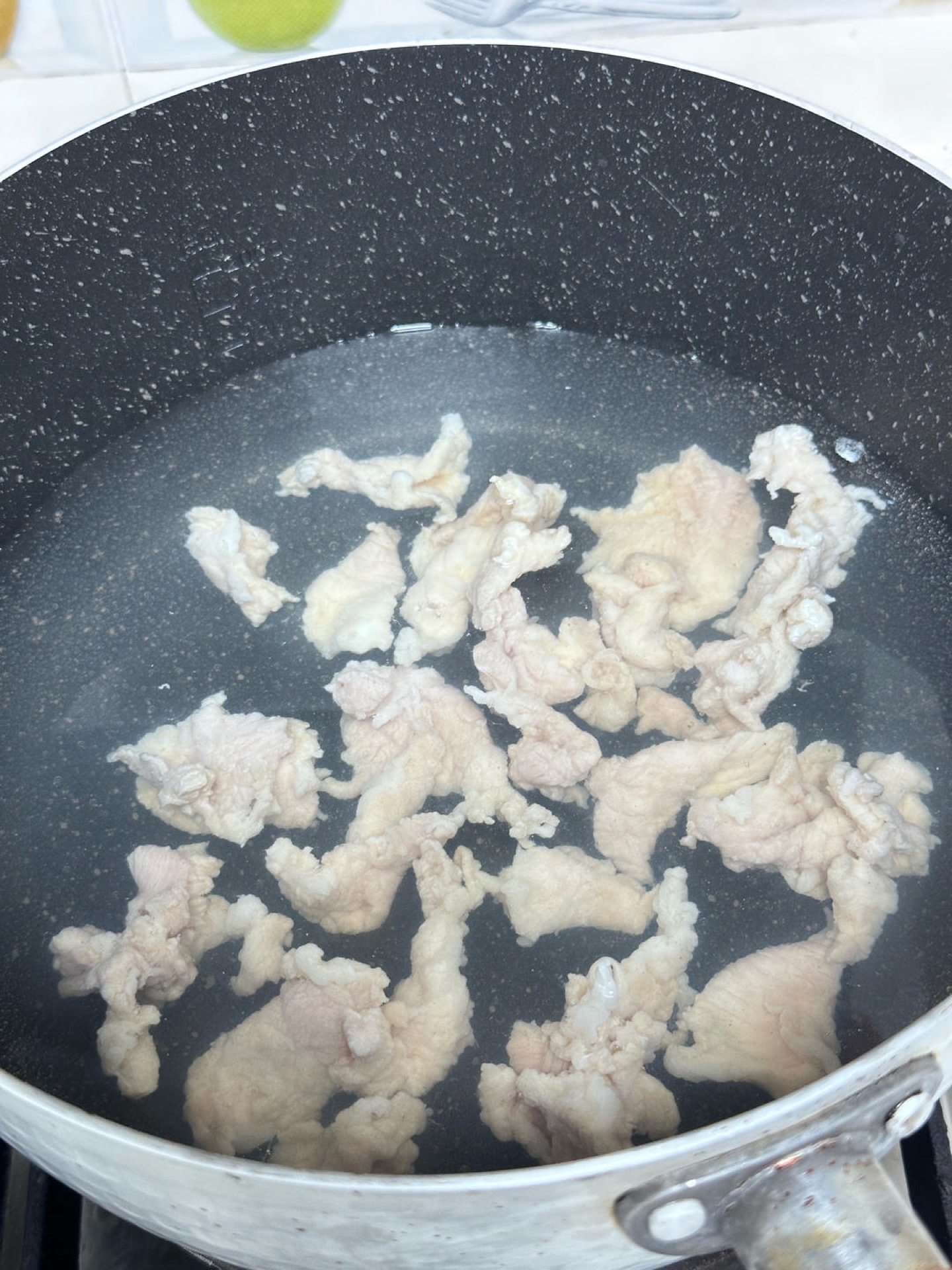 Bring water to a boil, then turn off the heat and slide in the pork slices one at a time.