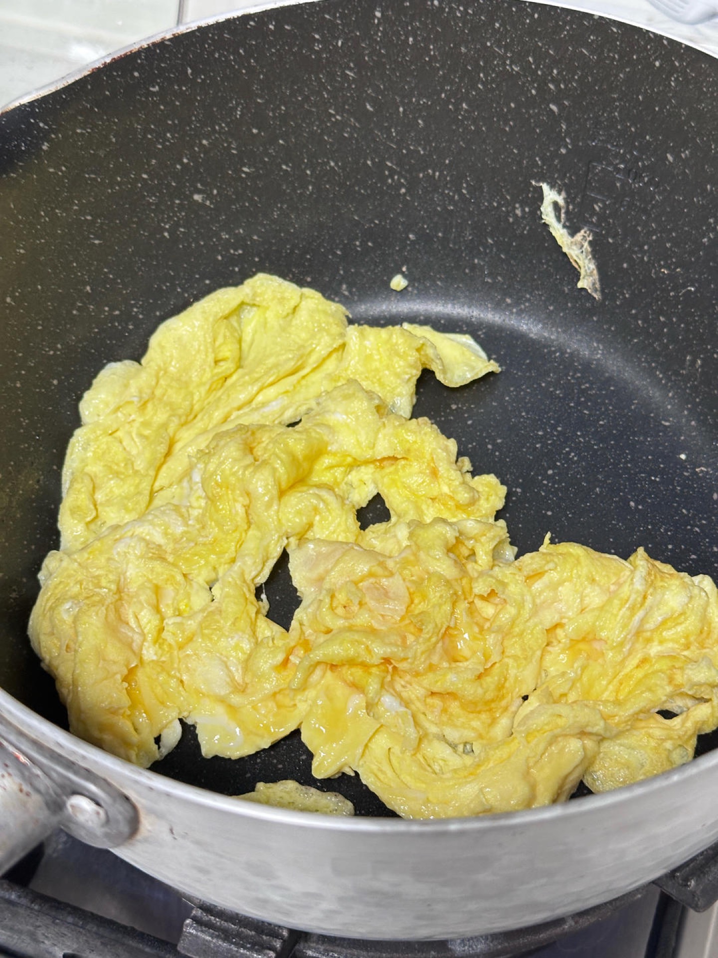 Scramble the eggs in the wok and set them aside.